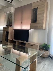 een woonkamer met een glazen tafel en een tv bij Apartamento El Cuco in Candeleda
