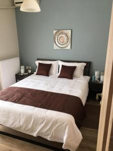 a bedroom with a large bed with brown and white sheets at Sea View Volos in Volos