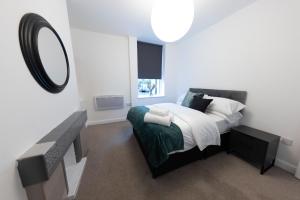 una camera da letto con un letto con specchio e lavandino di Havana House a Wolverhampton