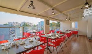 a restaurant with tables and chairs and a large window at Treebo Trend Elite 7 in Bangalore