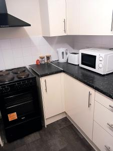 a kitchen with a stove and a microwave at 32 Elder Drive Chester CH4 8PD in Chester