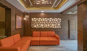 a waiting room with an orange couch and a window at Treebo Trend Elite 7 in Bangalore