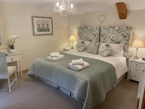 a bedroom with a bed with two towels on it at Millstream Cottage B & B in Dunster