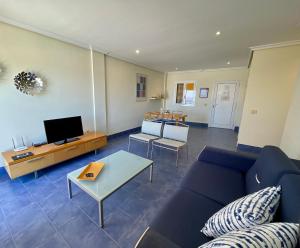 een woonkamer met een blauwe bank en een tv bij RentOnTheBeach in Los Cristianos