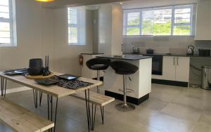 a kitchen with two bar stools and a table at Port St Francis - QuarterDeck in St Francis Bay