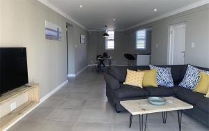 a living room with a couch and a table at Port St Francis - QuarterDeck in St Francis Bay