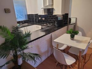a kitchen with a table and a white table and chairs at Rent Unique the Otford modern home 1 bed with mezzanine in Crawley