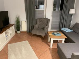 a living room with a couch and a chair and a table at Möwennest 13 Scharbeutz in Scharbeutz