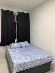 Bett in einem Zimmer mit schwarzen Vorhängen in der Unterkunft Apartamento Zona Norte 2qts in Rio de Janeiro