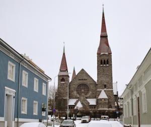 a church with two towers with snow on the street at Modern Rustic Stay in Tampere