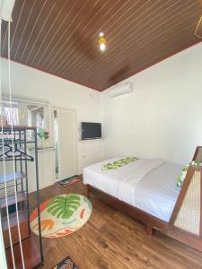 1 dormitorio con 1 cama y TV en una habitación en PALAGAN HUIS, en Kejayan