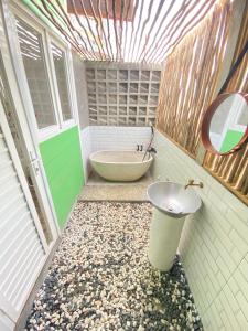 y baño con lavabo y bañera. en PALAGAN HUIS, en Kejayan