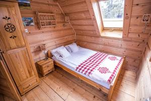 Dormitorio de una cabaña de madera con cama en Wooden Tatra House en Zakopane