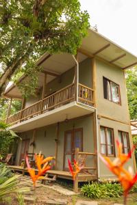 a house with a balcony on the side of it at Suites surf house itamambuca in Ubatuba