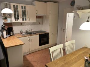 a kitchen with white cabinets and a table with chairs at Möwennest 13 Scharbeutz in Scharbeutz