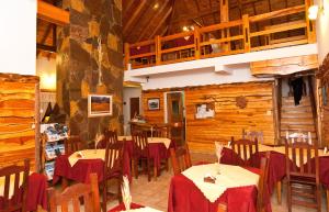 a dining room with tables and chairs and wooden walls at Hosteria Al Paraiso in Villa Pehuenia