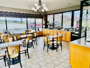 a dining room with tables and chairs in a restaurant at Super 8 by Wyndham Corbin KY in Corbin