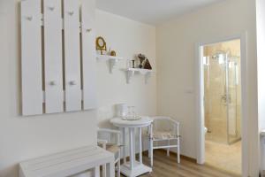 a white bathroom with a table and a mirror at Naš salaš in Sombor