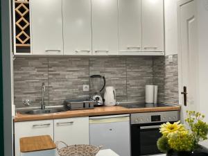 a kitchen with white cabinets and a sink at Prestige Apartment in Novi Sad