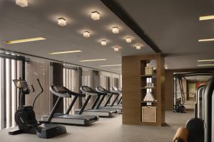 a gym with a row of treadms and elliptical machines at Rosewood Beijing in Beijing