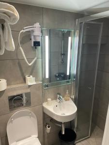uma casa de banho com um chuveiro, um WC e um lavatório. em Mary's Hotel République em Paris