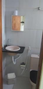 La salle de bains est pourvue d'un lavabo, de toilettes et d'un miroir. dans l'établissement Flat Santa Maria, à Fortaleza