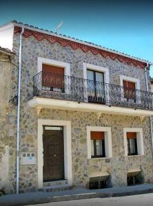Las Caldas de Boñar Casa alquiler completo في بونيار: مبنى حجري فوقه شرفة