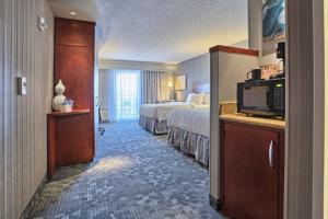una camera d'albergo con letto e TV di Courtyard by Marriott Harrisburg West/Mechanicsburg a Mechanicsburg