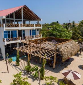 budynek na plaży ze słomianym dachem w obiekcie Merakai Hostel Rincon del Mar w mieście Rincón