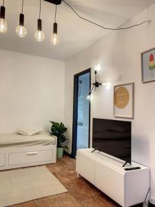 ein weißes Zimmer mit einem Bett und einem Kamin in der Unterkunft IBIZA -Sublime studio Place de la Trinité- Netflix in Toulouse