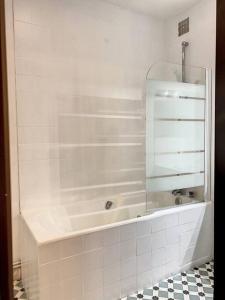 ein weißes Bad mit einer Dusche und einer Glastür in der Unterkunft IBIZA -Sublime studio Place de la Trinité- Netflix in Toulouse