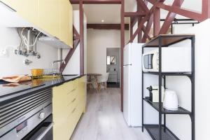 リスボンにあるBright Santa Catarina by Homingのキッチン(黄色と白のキャビネット、冷蔵庫付)