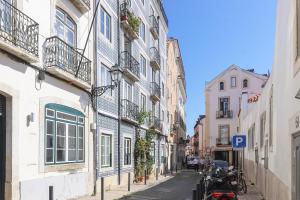 une ruelle étroite avec des bâtiments et une moto garée dans une rue dans l'établissement Bright Santa Catarina by Homing, à Lisbonne