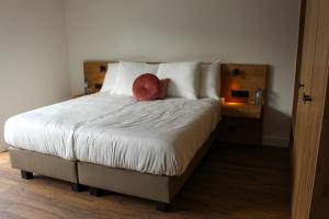 a bedroom with a bed with a red pillow on it at De Kasteelhoeve in Westmalle