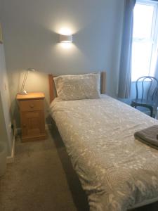 een slaapkamer met een bed, een tafel en een lamp bij Marine View Guest House in Worthing