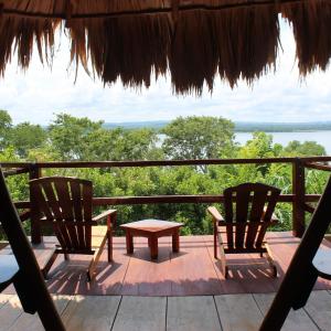 two chairs and a table on a deck with a view at Posada del Cerro in El Remate