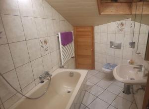 a bathroom with a sink and a tub and a toilet at Sigrids Ferienwohnung Bad Tölz in Bad Tölz