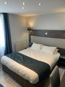 Schlafzimmer mit einem großen Bett mit einem Kopfteil aus Holz in der Unterkunft Mary's Hotel République in Paris