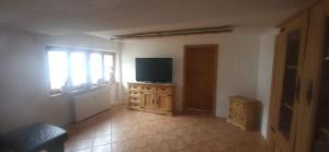 a living room with a television on a wooden dresser at Sigrids Ferienwohnung Bad Tölz in Bad Tölz