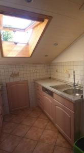 uma cozinha com um lavatório e uma clarabóia em Sigrids Ferienwohnung Bad Tölz em Bad Tölz