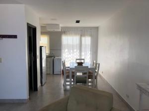 a kitchen and dining room with a table and chairs at Complejo Caribea in Quequén