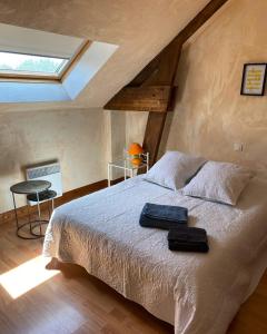 een slaapkamer met een bed met twee handdoeken erop bij Gîte Utah du DOMAINE DE SAINT-VIGOR 