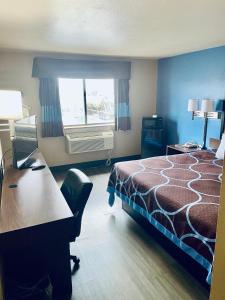 a hotel room with a bed and a desk and a window at Super 8 by Wyndham Corbin KY in Corbin