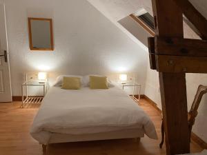 een slaapkamer met een bed met 2 tafels en 2 lampen bij Gîte Utah du DOMAINE DE SAINT-VIGOR 