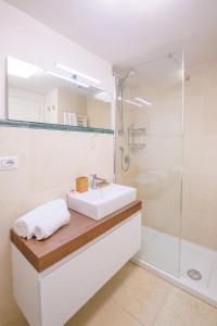 uma casa de banho branca com um lavatório e um chuveiro em UNYCA - Residenza San Niccolò em Florença