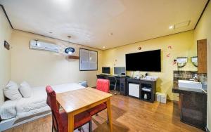 een woonkamer met een bank, een tafel en een tv bij Chakan Hotel in Gunsan