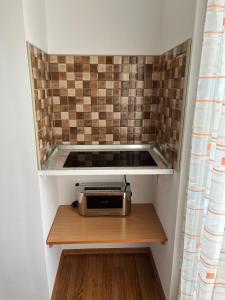 una piccola cucina con tostapane seduta su uno scaffale di Karolin Apartman a Bükfürdő