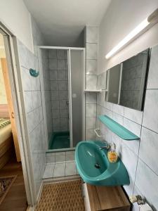 bagno con lavandino verde e doccia di Karolin Apartman a Bükfürdő