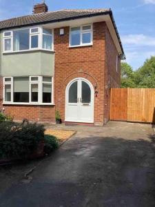 a brick house with a white door and a fence at Renovated home, fab location, garden, pet friendly and parking in Chester