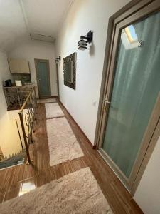 un pasillo con una puerta de cristal y dos alfombras en Negrean Residence, en Oradea
